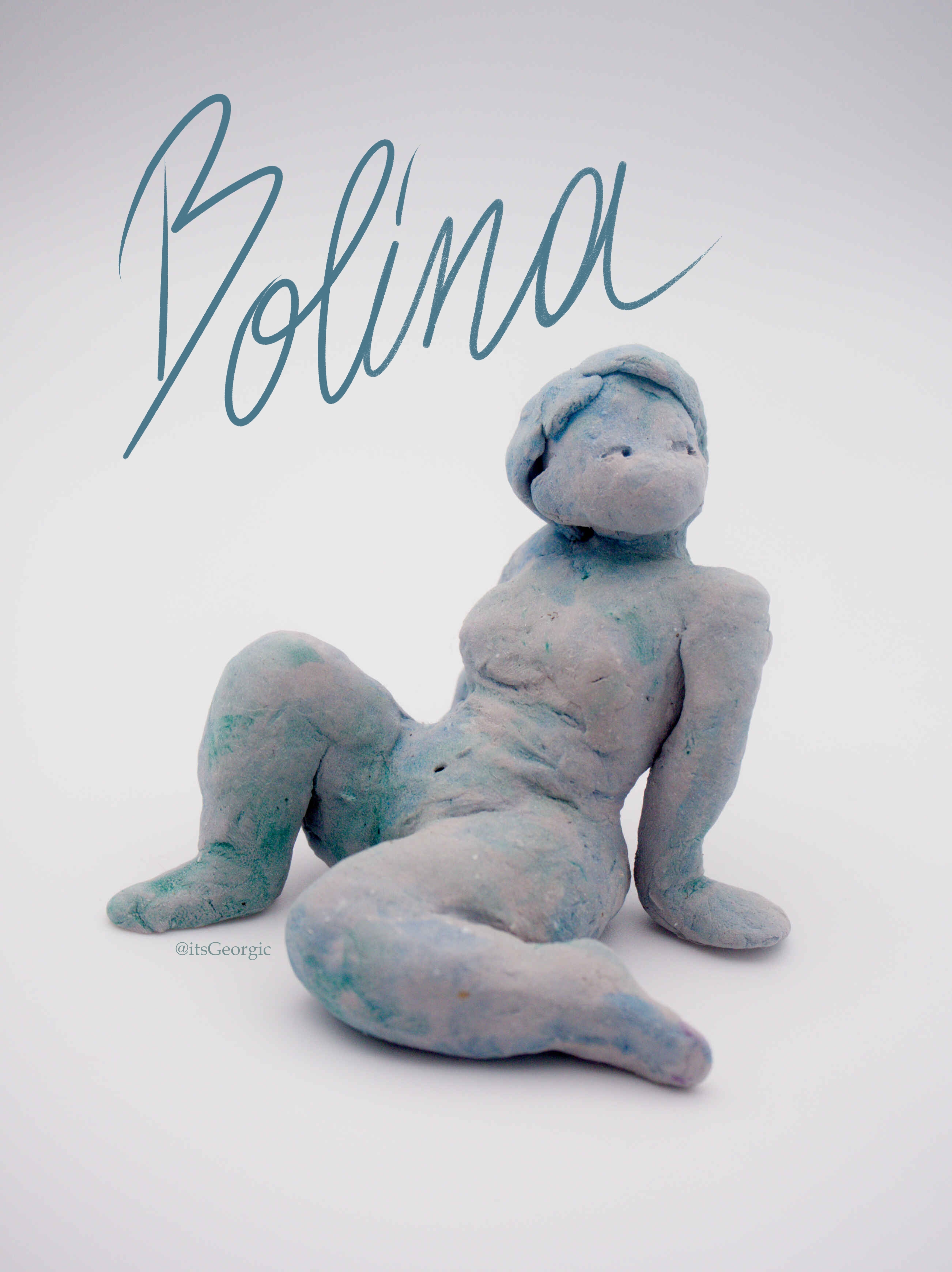 Photo d'une statuette d'une femme assise une jambe sur le côté et une autre fléchie, elle regarde en dehors du cadre. Elle est peinte en bleu avec un effet aquarelle. Son nom "Bolina" est écrit à la main au-dessus d'elle.