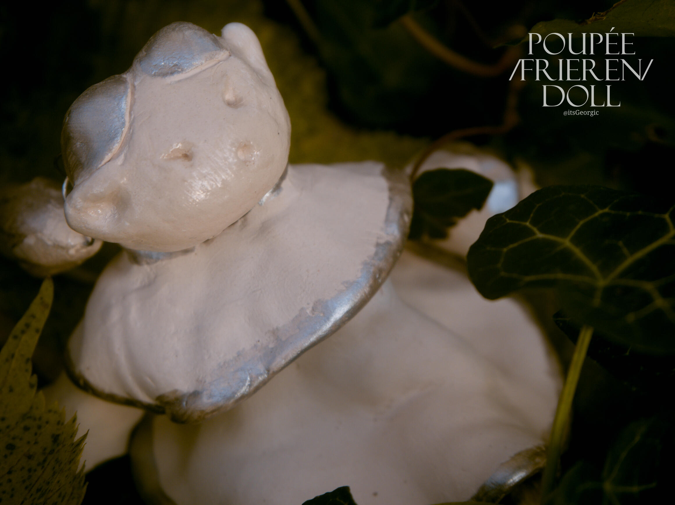 Photo de Frieren vue de 3/4 en contre-plongée dans  un parterre de lierre et de feuilles.