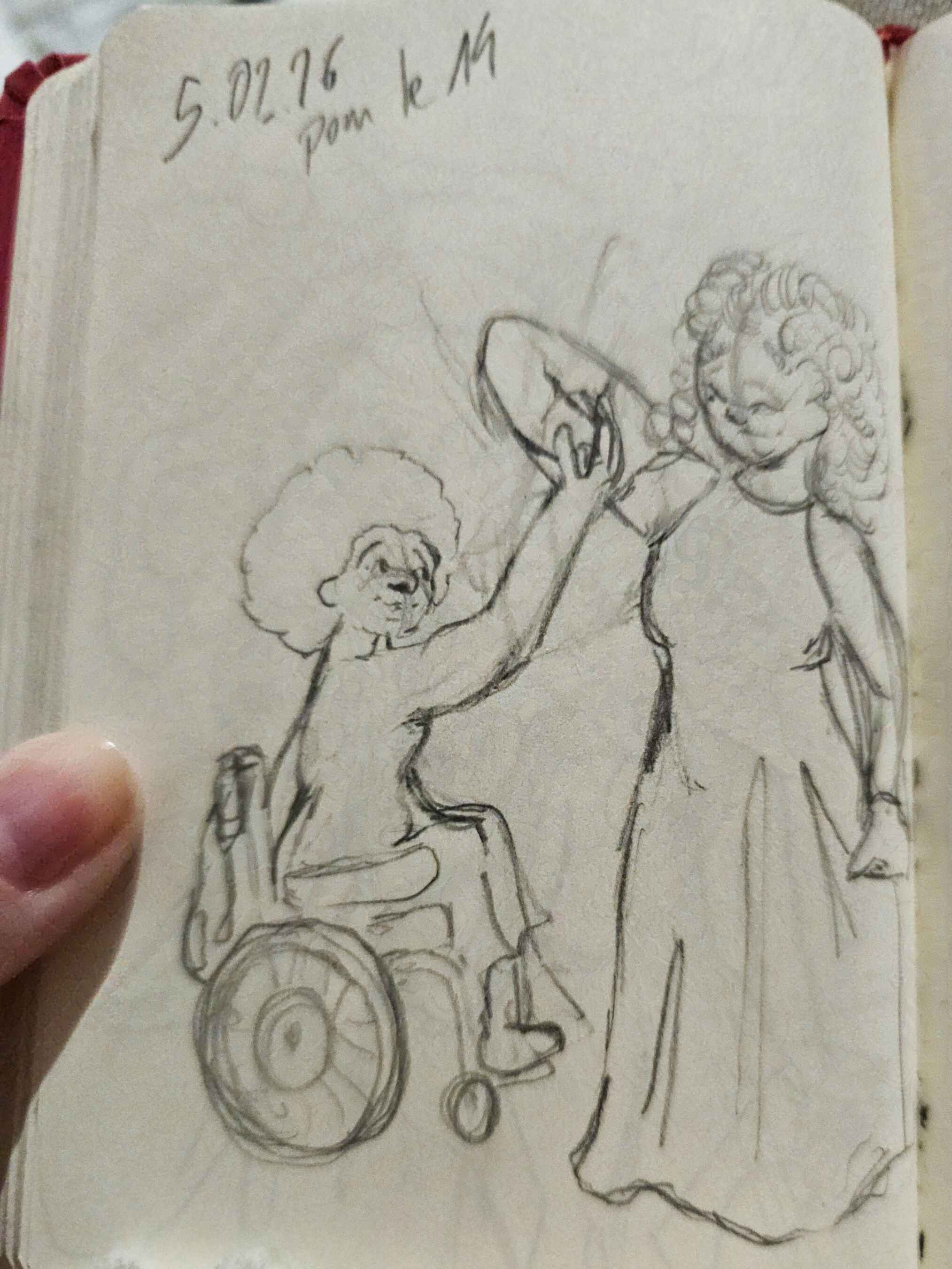 Photo d'un carnet de croquis d'une esquisse de deux femmes, dont une en fauteuil roulant, dansant ensemble.