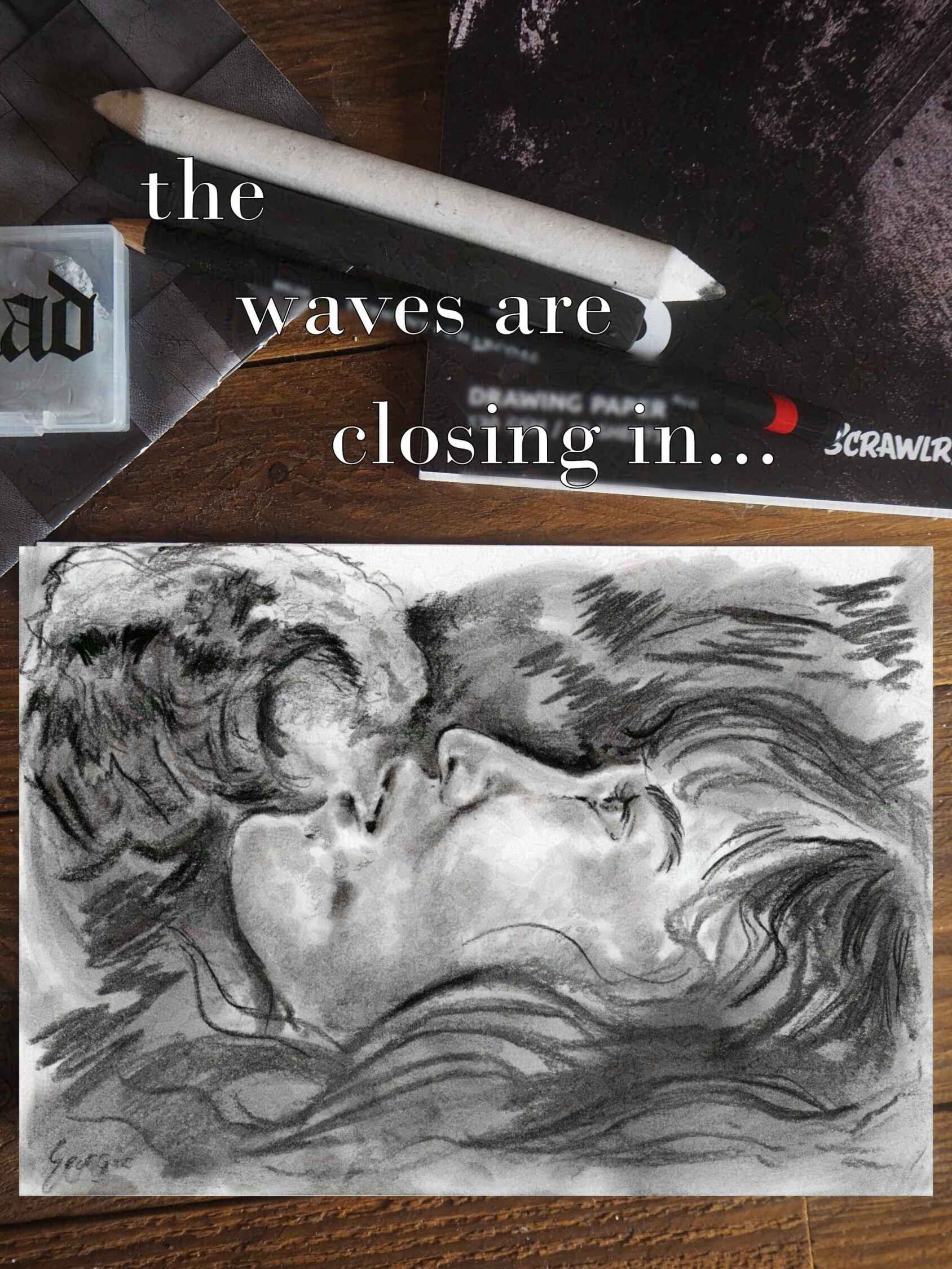 photo du dessin au fusain d’une jeune femme flottant devant une vague, on voit autour du dessin sur la photo différentes formes de fusain