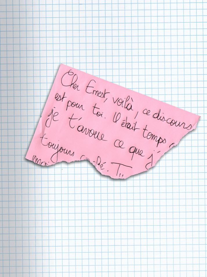 Morceau de papier déchiré posé sur la page. On peut distinguer quelques mots : Cher Ernest, voilà, ce discours est pour toi. Il était temps [...] je t'avoue ce que j' [...] toujours c[.]ché. Tu [...]